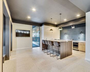 a large kitchen with a bar and a tv